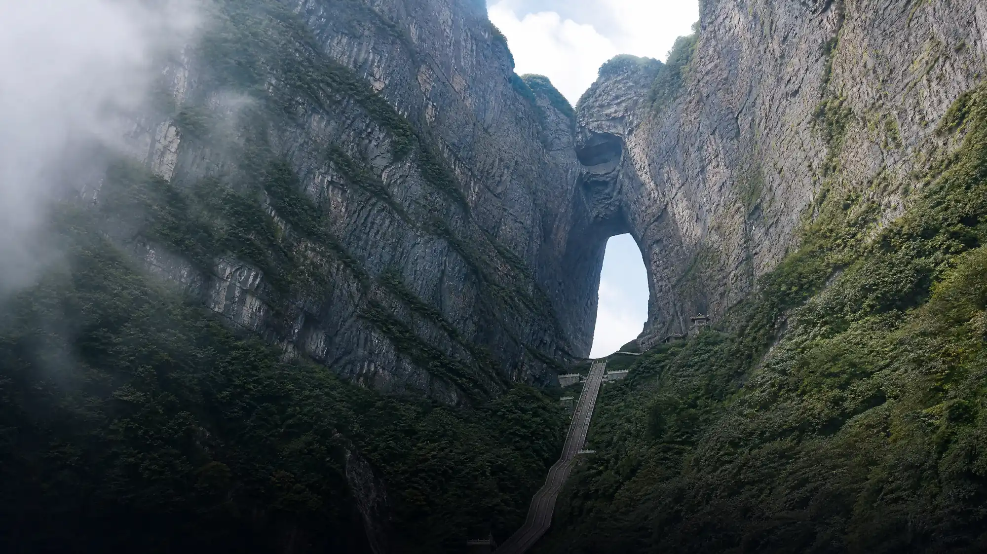 Experience high-altitude karst cliffs, the 99-bend road, and the natural archway of Tianmen Cave. Plan your visit to this engineering marvel rising above Zhangjiajie.