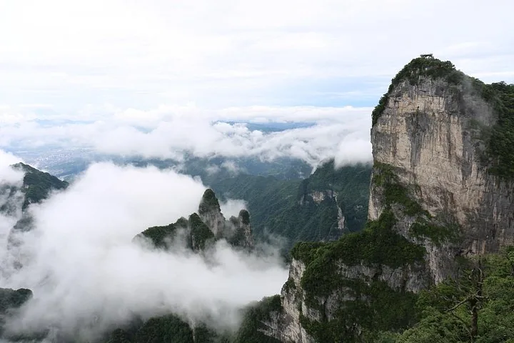 Steep cliffs of Tianmen Mountain rising above clouds and valleys