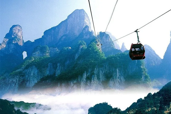 Cable car traveling towards Tianmen Mountain over a sea of clouds